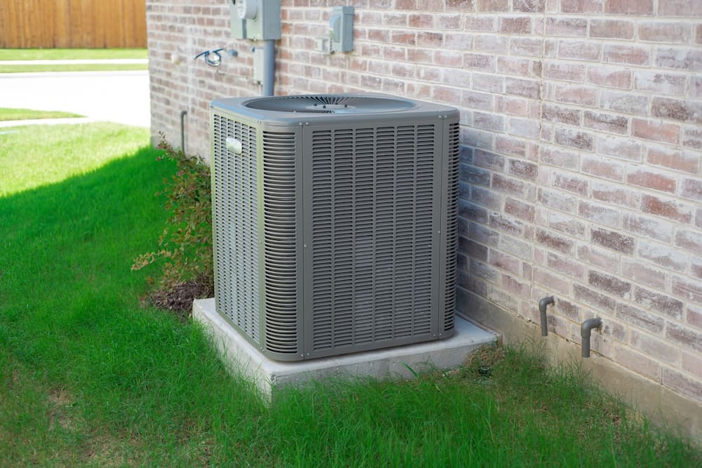Outdoor air conditioner on a concrete slab in the grass